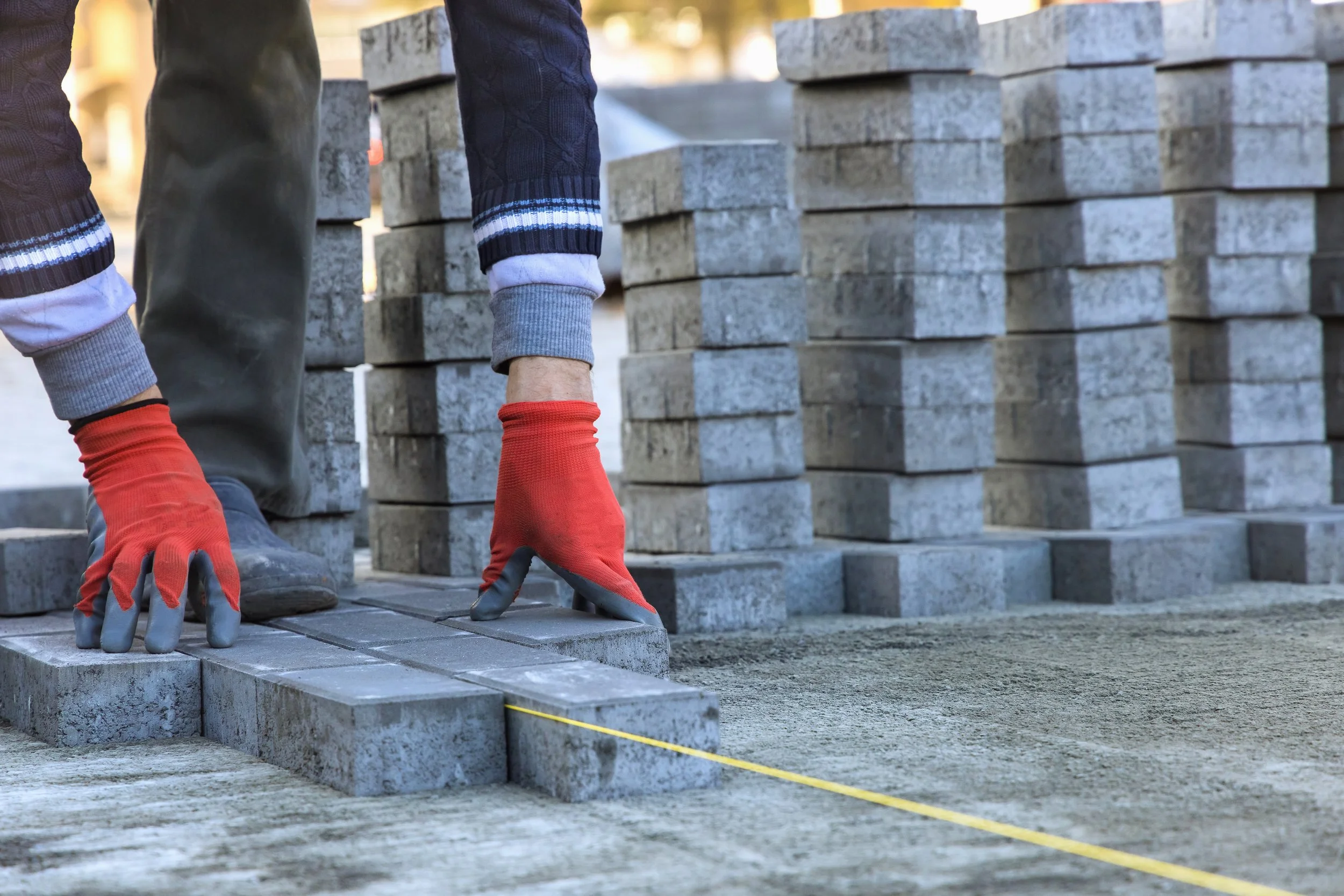 installing-paving-construction-stone-block-sidewalk-road-working-interlock-construction-site.jpg