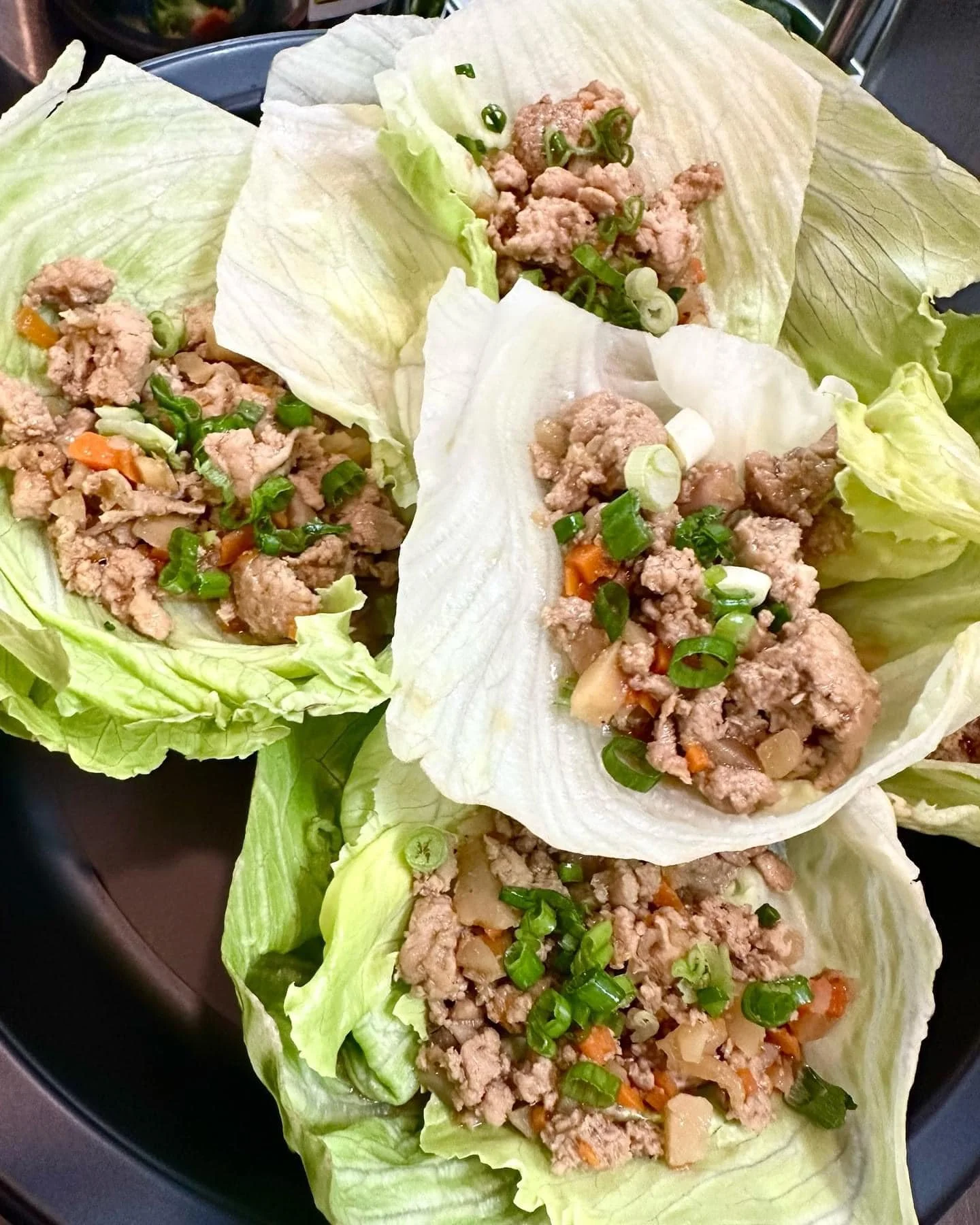 Lettuce wraps filled with ground meat, chopped green onions, and diced vegetables.