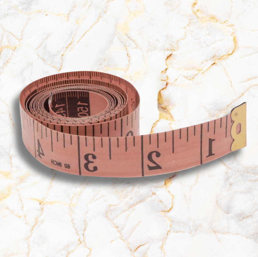 Pink measuring tape coiled on a white marble surface.