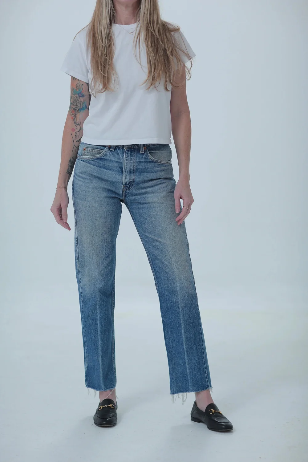 Levi's 505 medium wash, fitted in hips with a little room in waist, front view with hip leaning