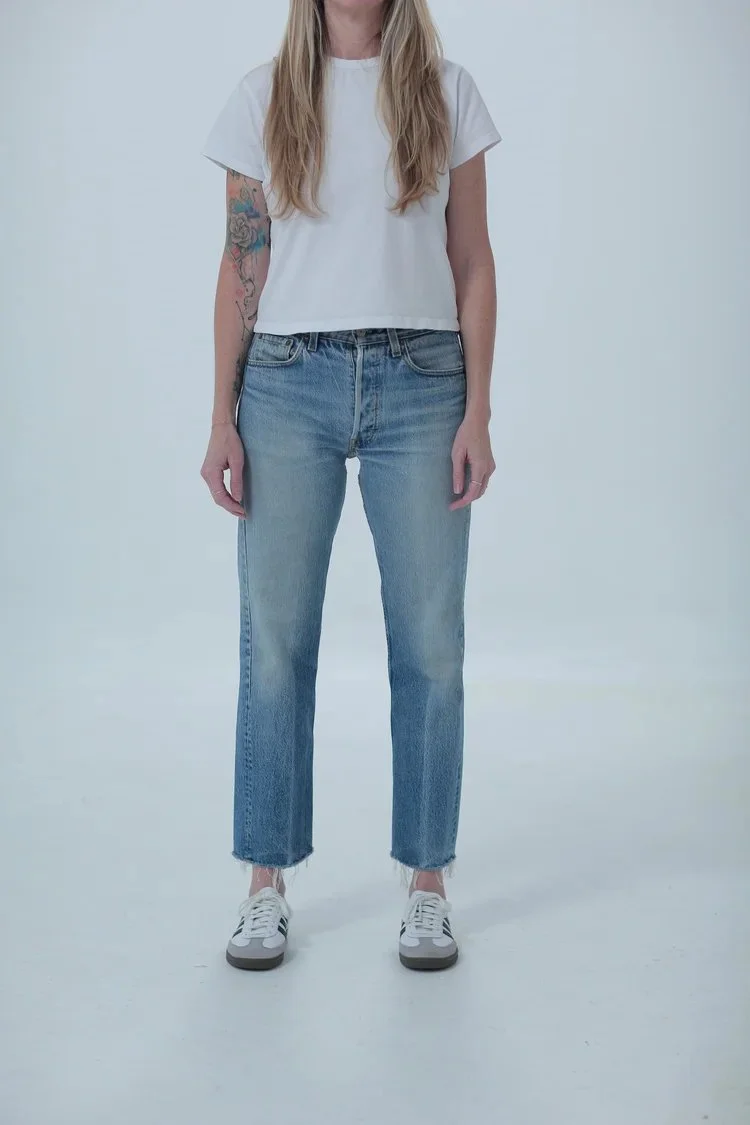 Levi's 501 classic medium wash, fitted with cropped raw hem, front view