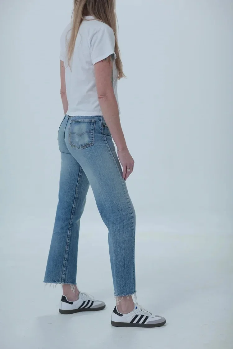 Levi's 501 classic medium wash, fitted with cropped raw hem, side view