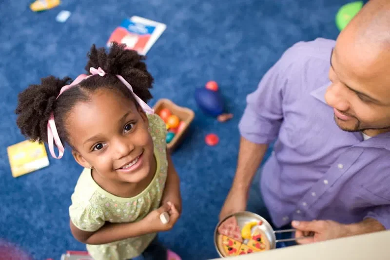 Young African-American girl and her father engaged in play
