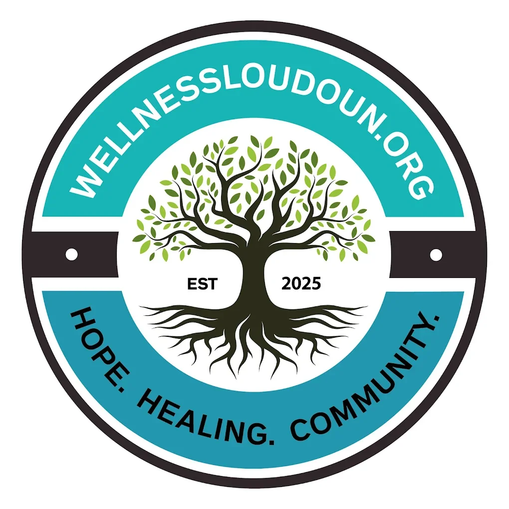 A circular logo for Wellness Loudoun with a tree at its center, and the website wellessloudoun.org written around the top. The tree has a black trunk and branches with green leaves, and the roots are visible. The words 'Hope. Healing. Community.' are written around the bottom of the circle, and 'EST 2025' is written inside the circle on either side of the tree trunk.