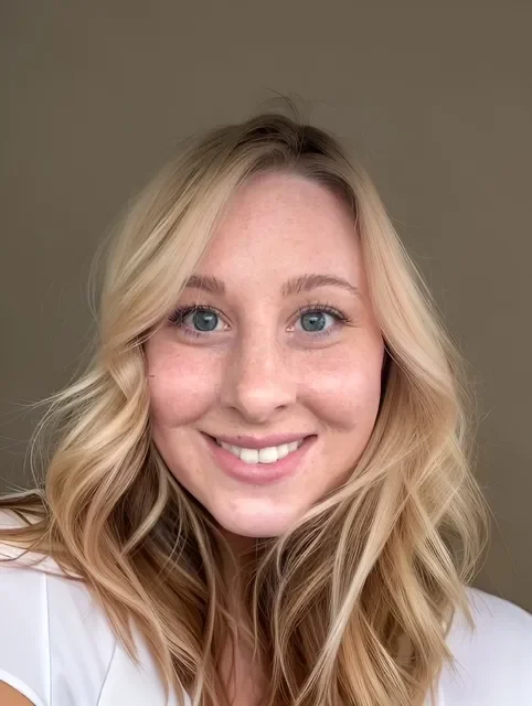 A young woman with blonde hair and blue eyes smiling at the camera.