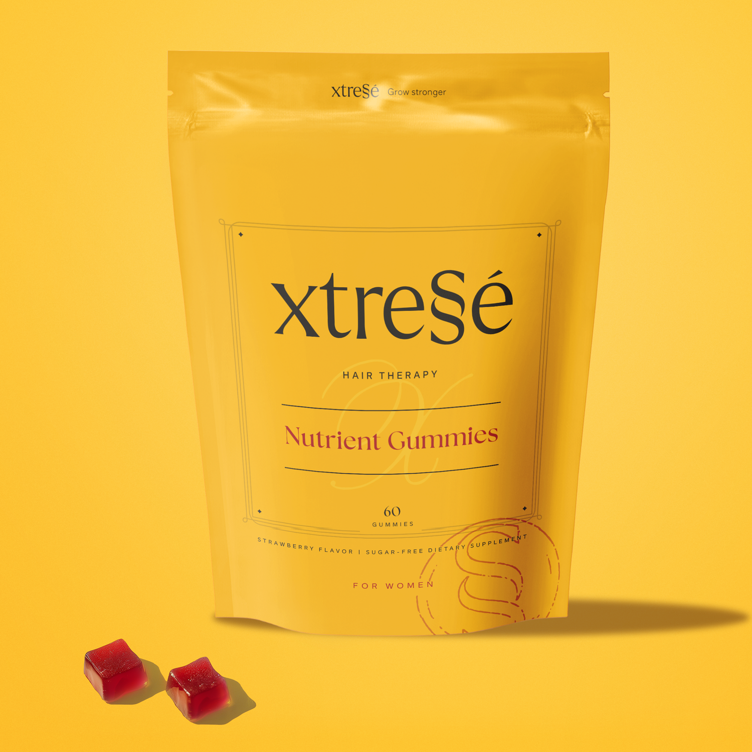 Yellow package of Xtresé Nutrient Gummies with two red gummy candies placed in front of it, against a yellow background.