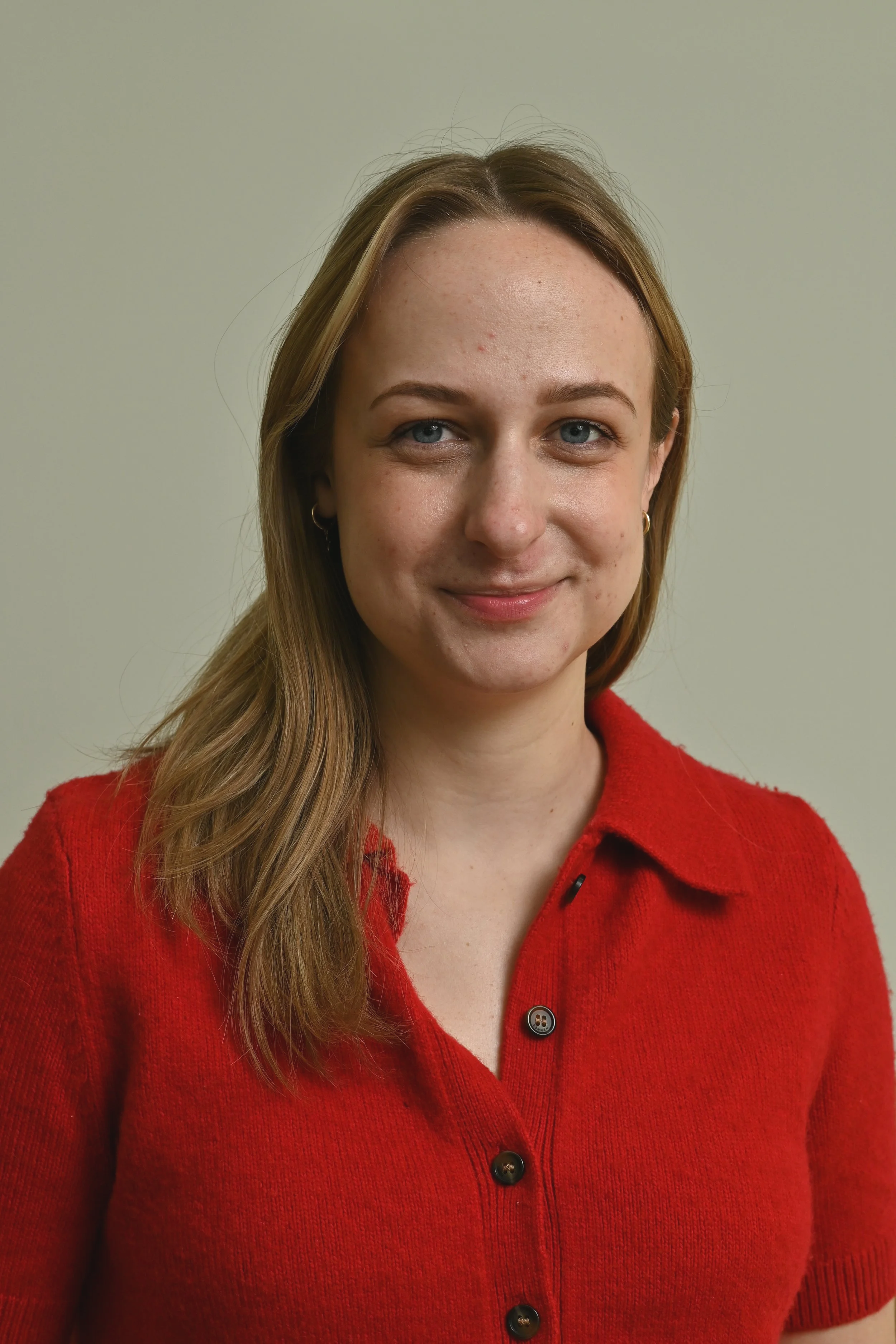 head shot of a woman smiling in red shirt