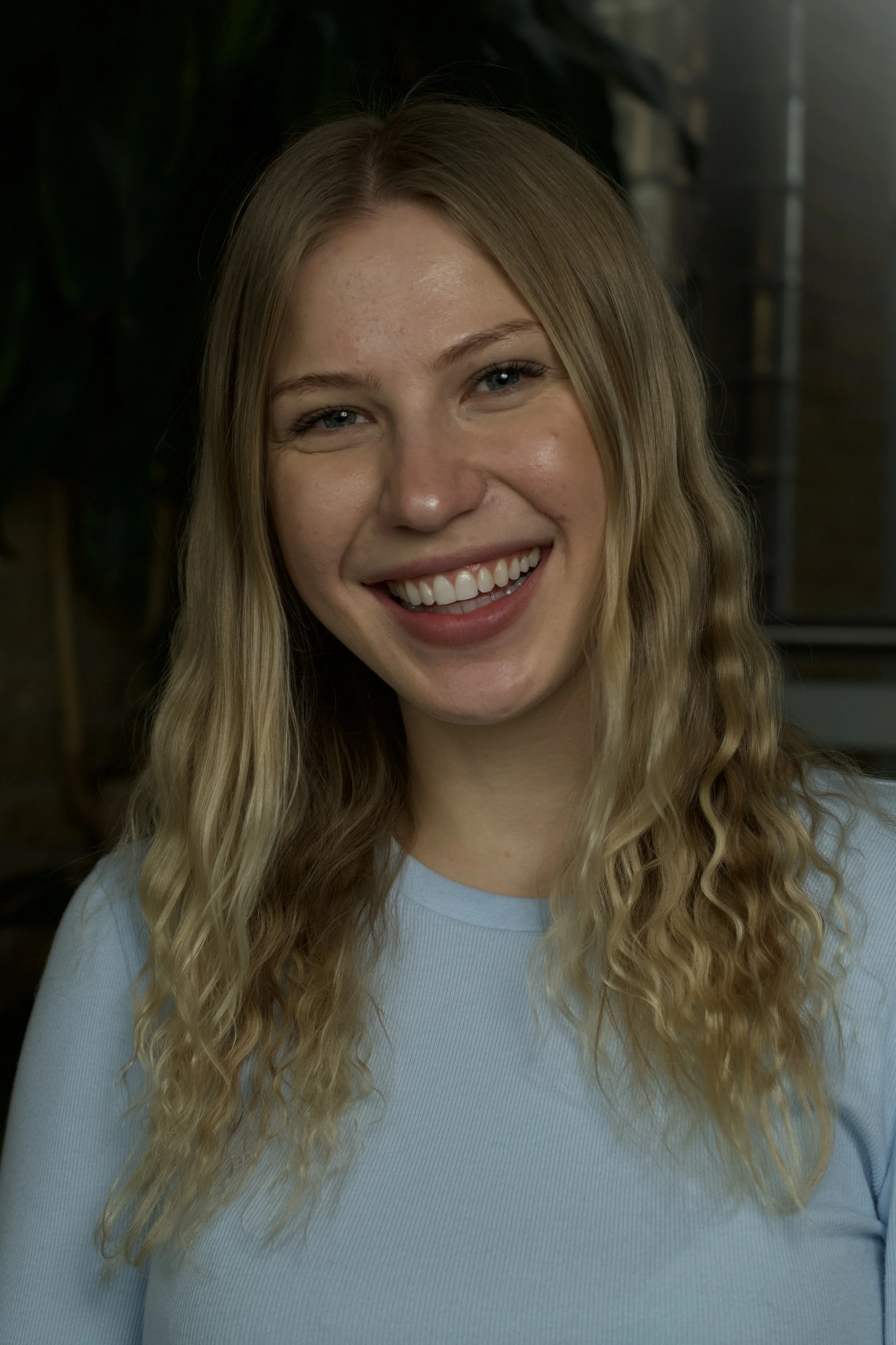 close up of a woman smiling in a blue shirt