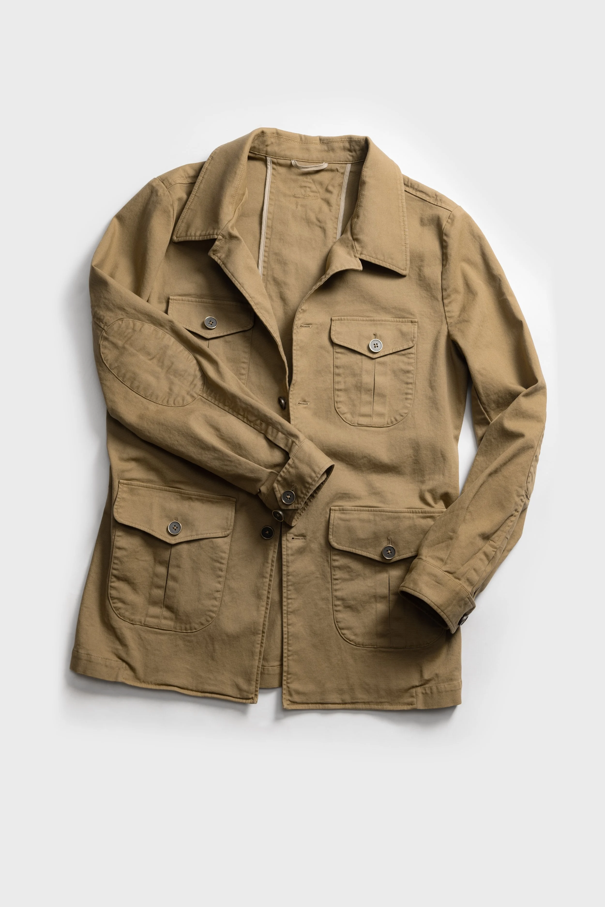 A tan or khaki long-sleeve casual shirt jacket with four front pockets, button closures, and a collar, laid flat on a white background.