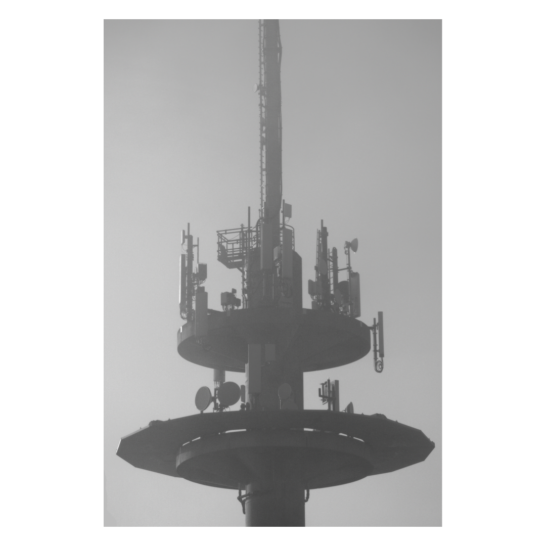 Funk- und Mobilfunksendemast auf einem hohen Turm gegen den Himmel.