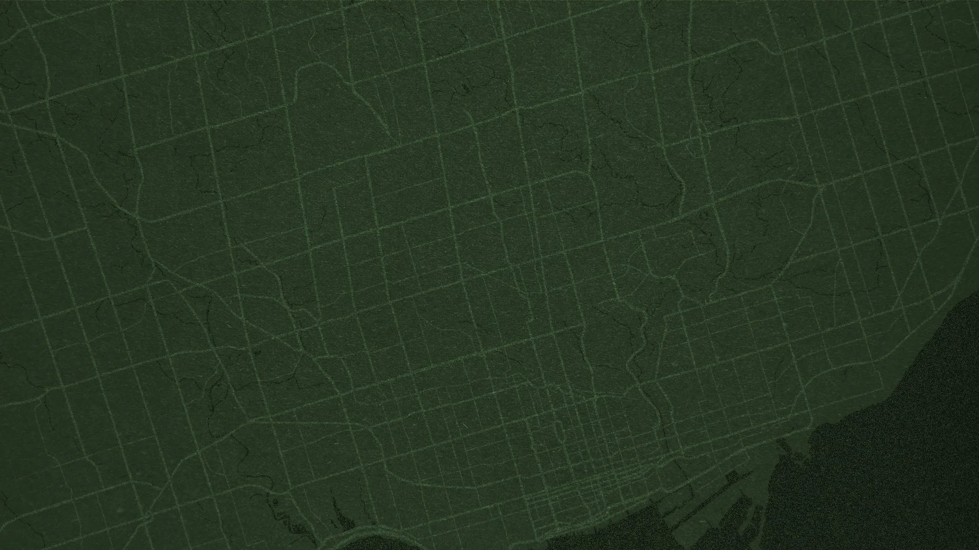 Close-up image of a dark green map with street grids and river lines in a slightly lighter green.