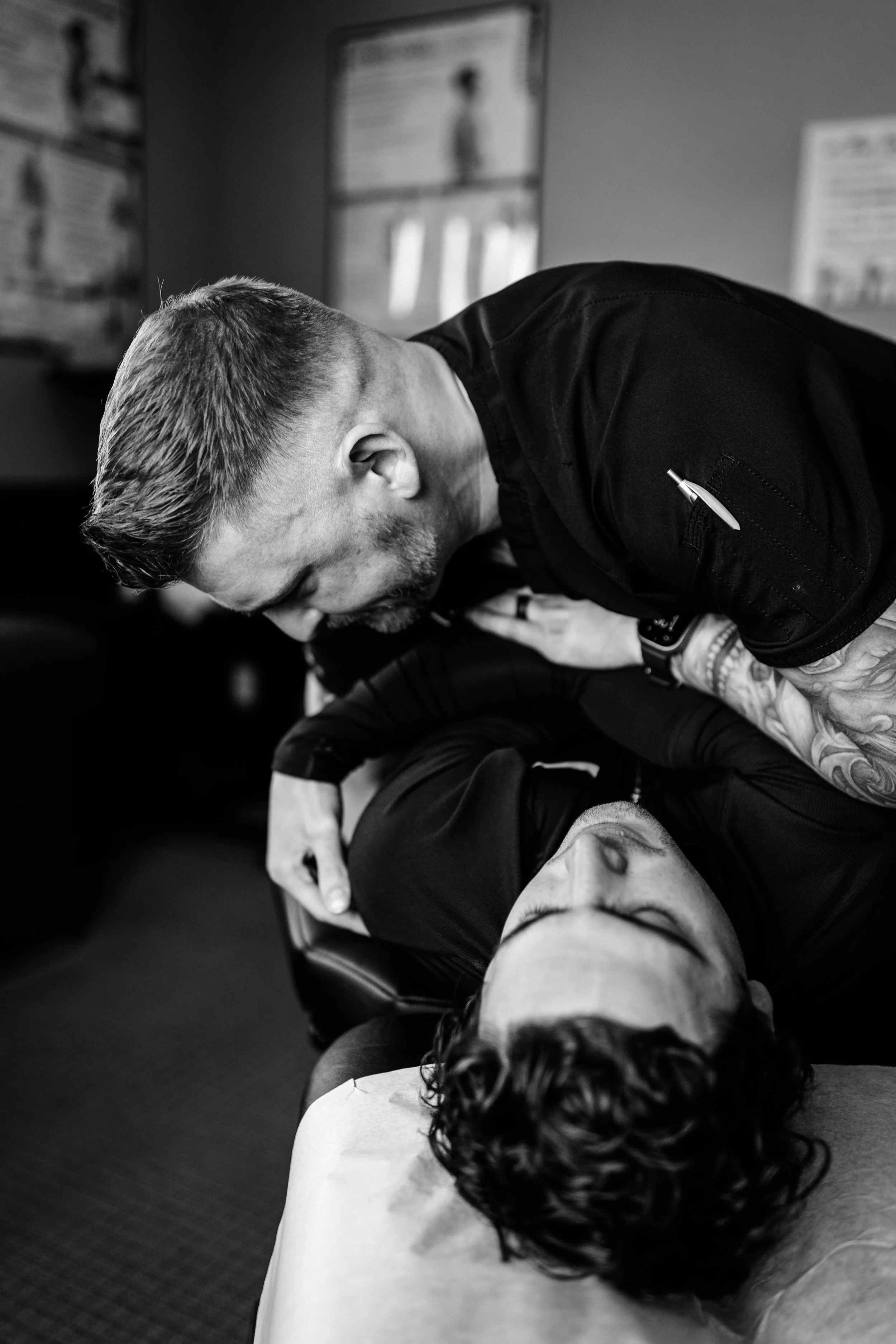 A man performing CPR on a woman lying on the floor with her eyes closed as part of a training or rescue scenario.