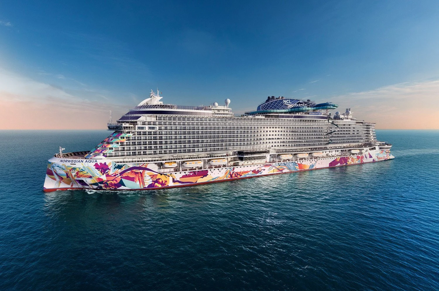 Large cruise ship named Norwegian Aqua sailing in the ocean during sunset with a colorful design along the hull.