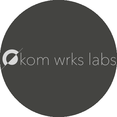 Logo of Kom Wrks Labs on a dark background.