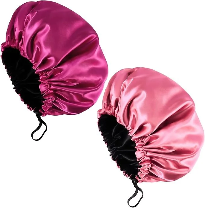 Two pink satin sleep masks with black elastic straps, shown against a white background.