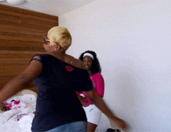 Two women dancing in a bedroom, one in a navy top and the other in a pink top. Nene Leakes from Real Housewives of Atlanta twirling carefree.
