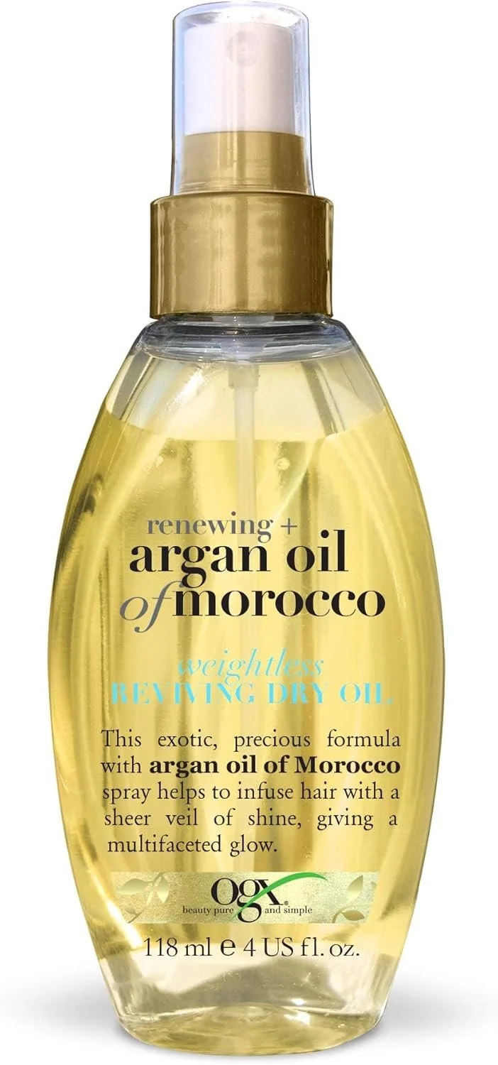 A clear plastic spray bottle containing yellowish hair oil with a spray nozzle and gold-colored cap, labeled as argan oil of Morocco for renewing and revitalizing hair.
