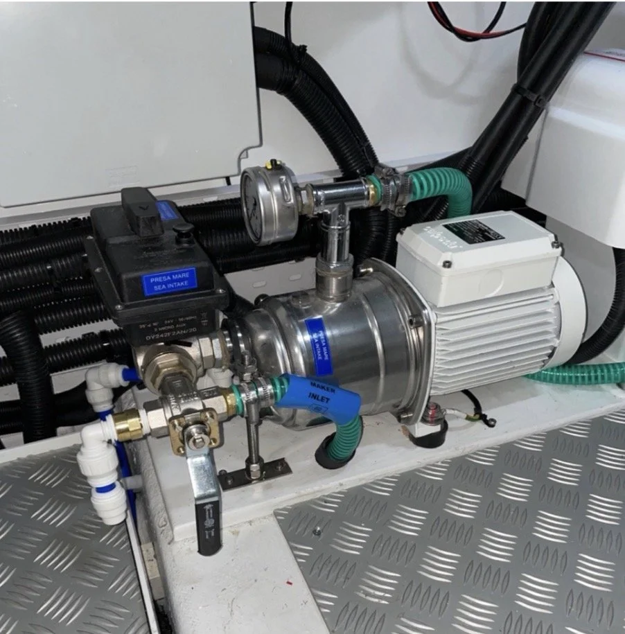 Industrial water pump system with pipes, gauges, and electrical components on a metal platform.