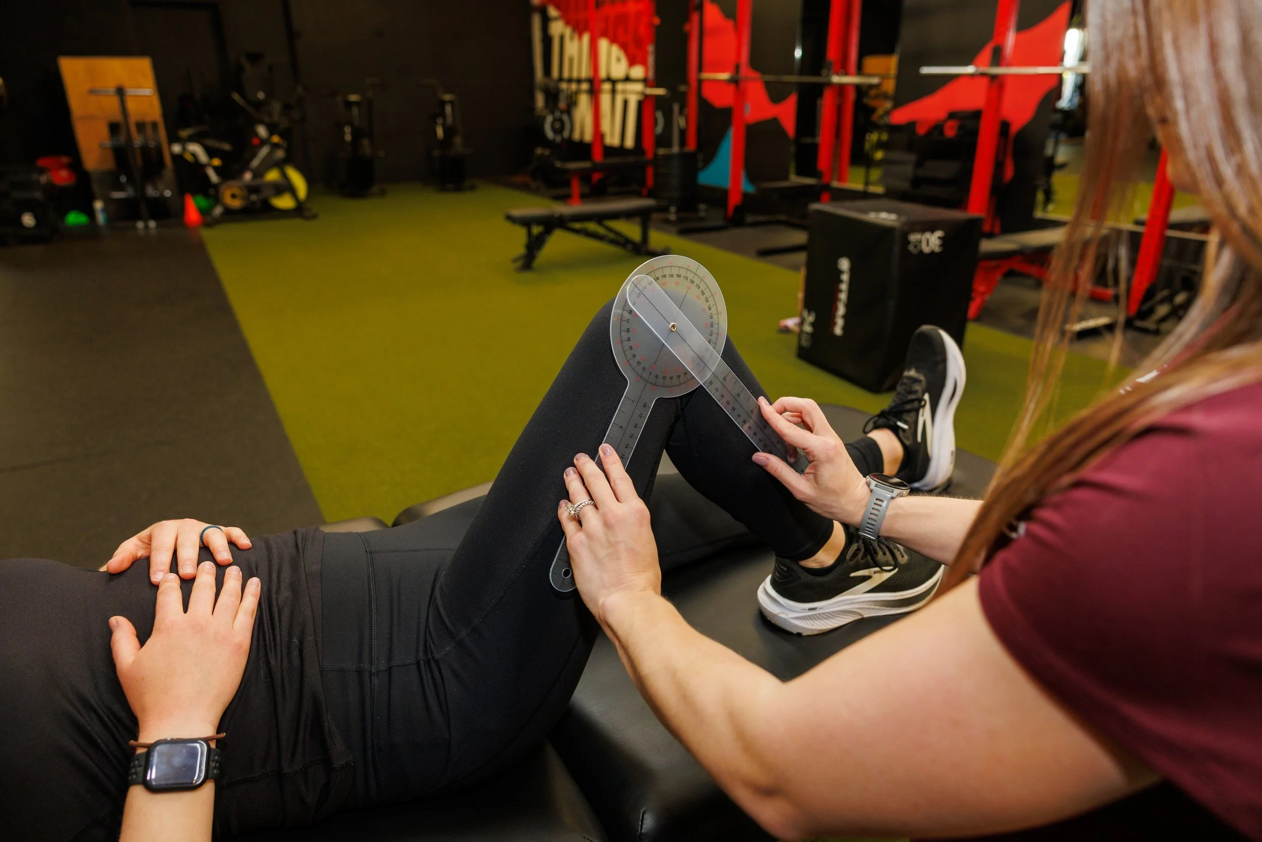 Physical therapist measuring a runner's knee angle with a goniometer
