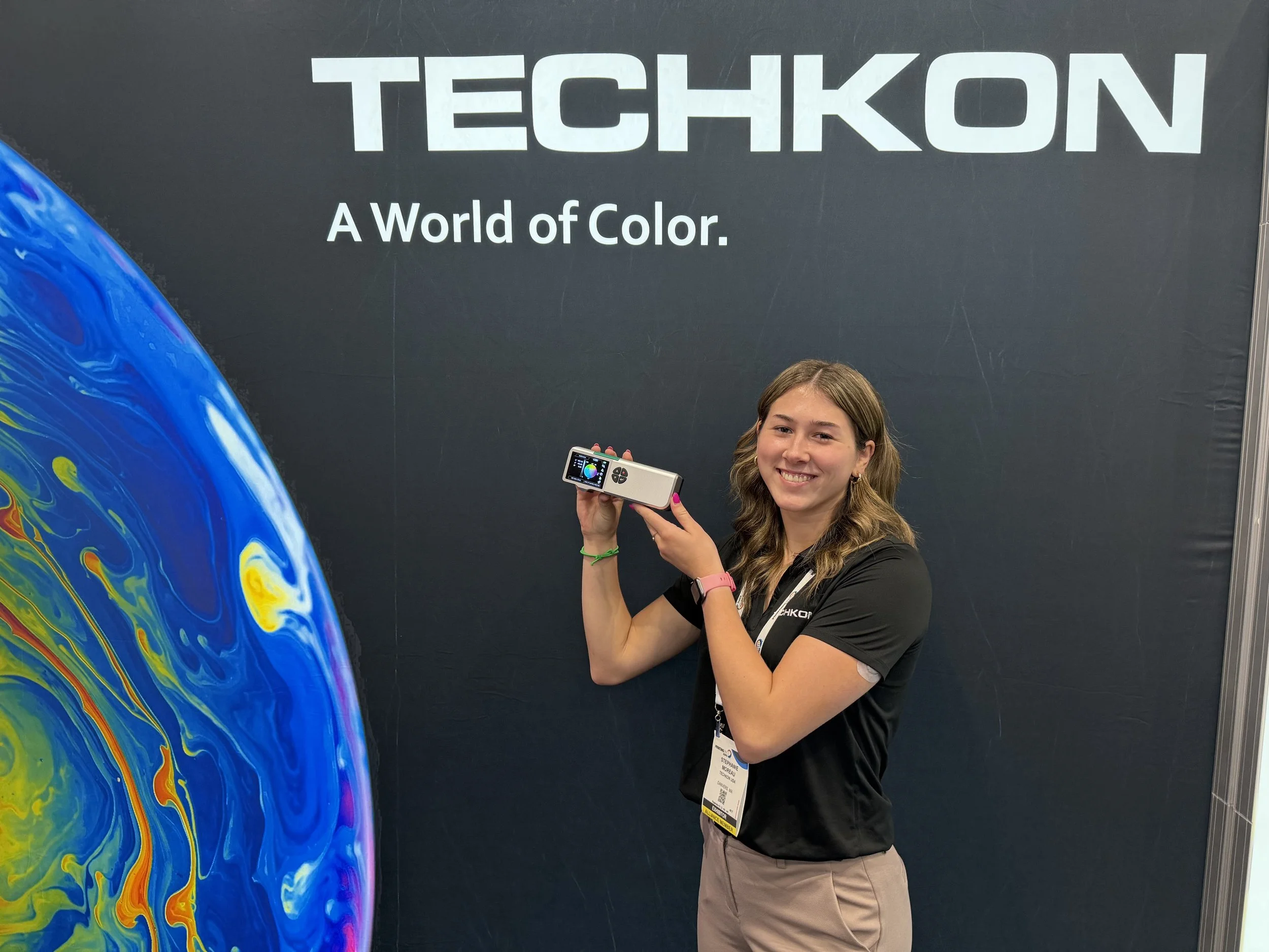 Stephanie in front of Techkon's logo.
