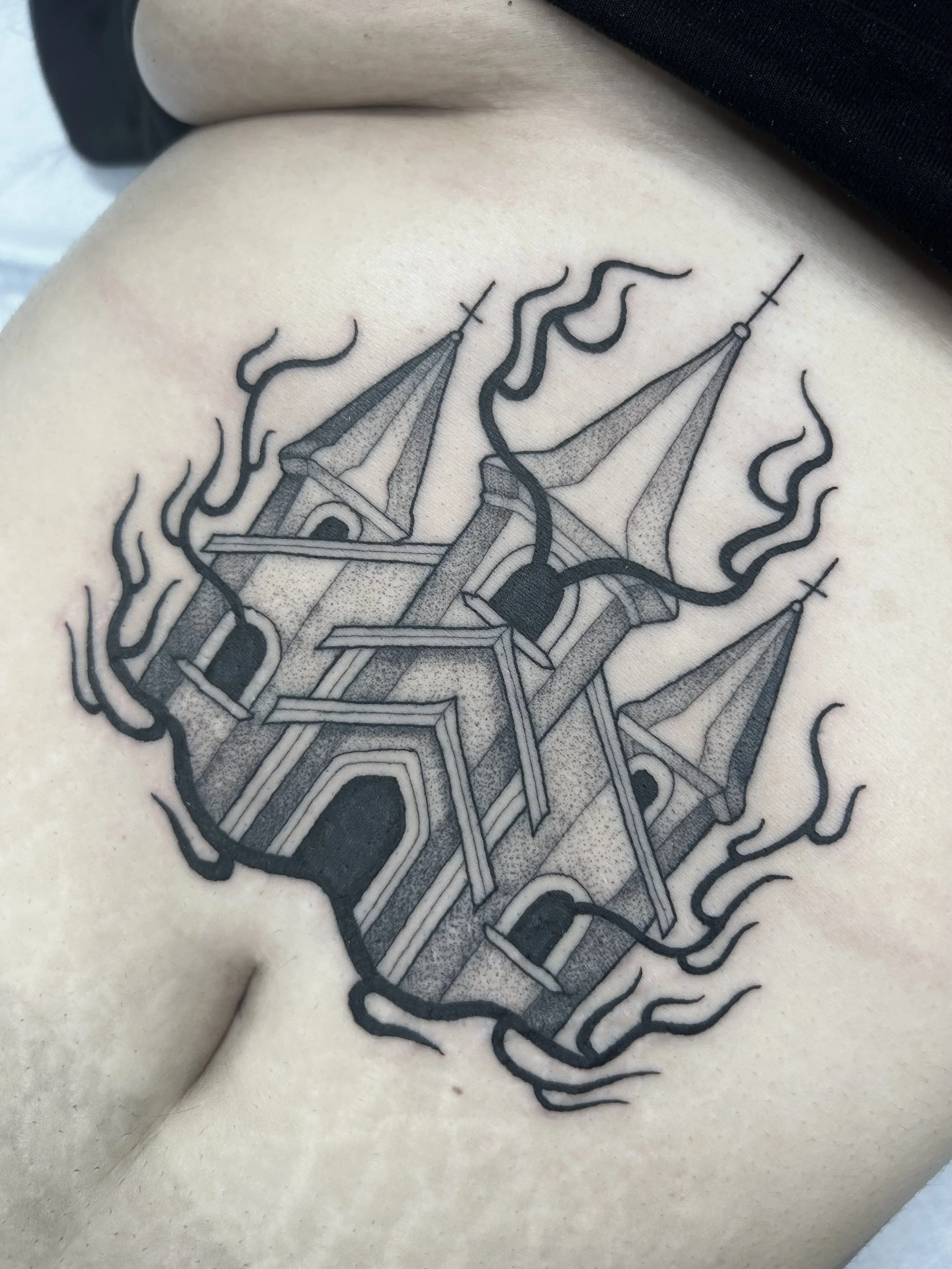 A black line tattoo of a geometric structure with towers surrounded by swirling lines, on a person's side.