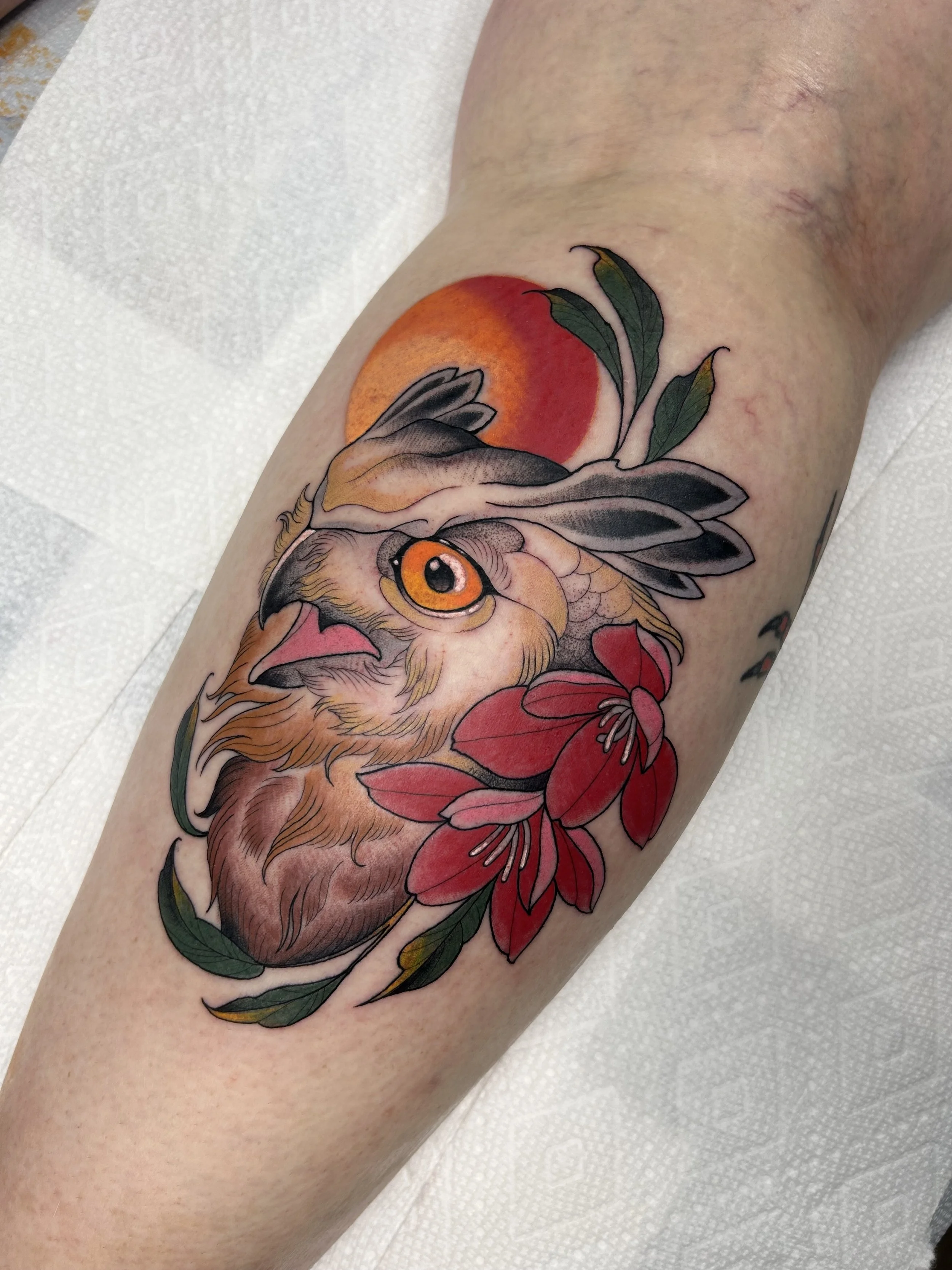 Colorful tattoo of a fox with orange fur, surrounded by red flowers and green leaves, on a person's arm.
