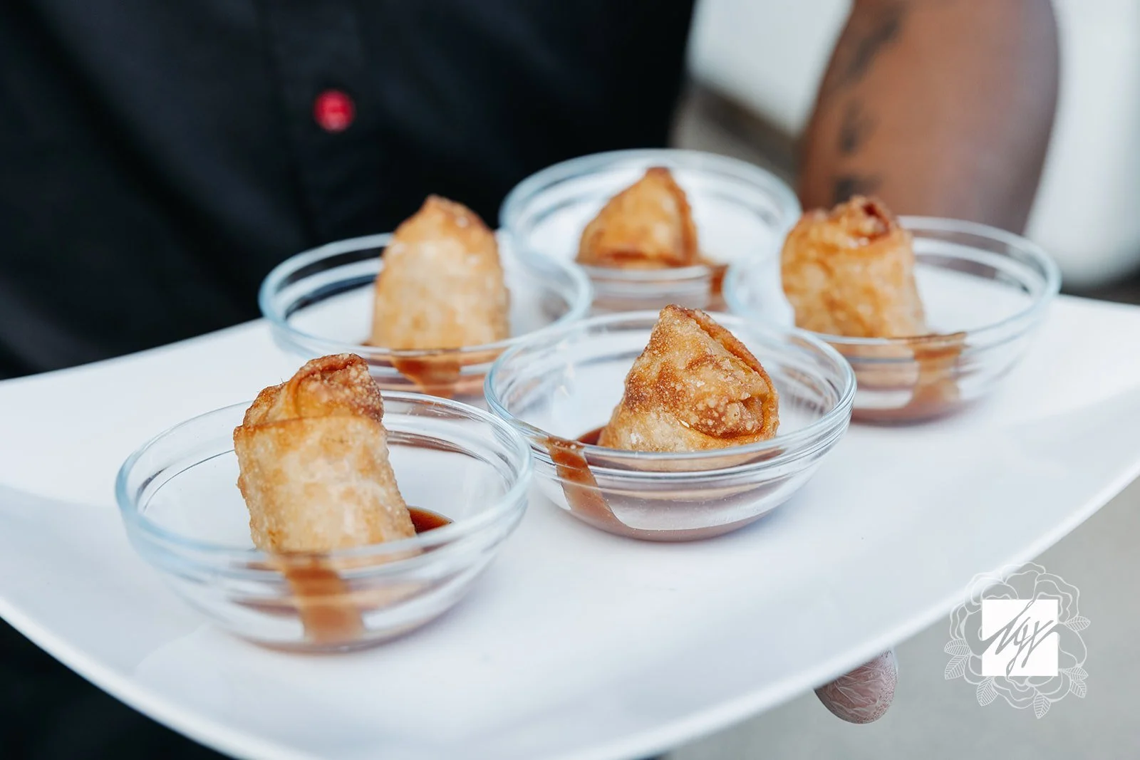 Passed hors d'oeuvres & imaginative takes on classic wedding food by luxury in-house catering at JPS Events at Regions Tower in Downtown Indy: five small glass bowls with fried spring rolls drizzled with sauce.