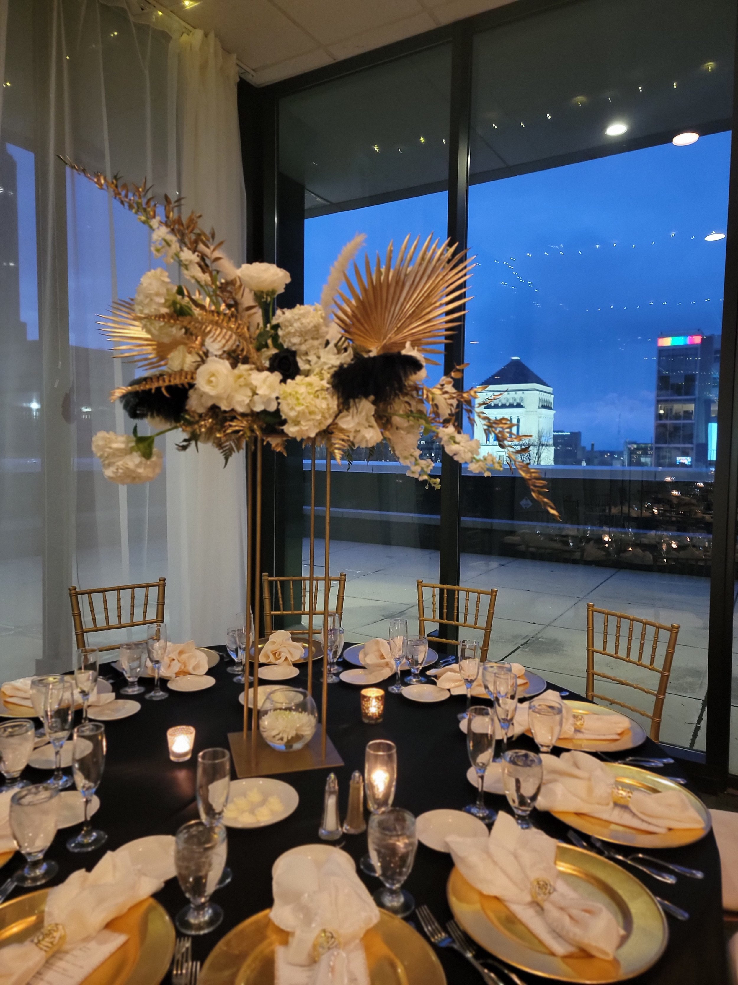 Executive corporate dining setup at JPS Events at Regions Tower, showcasing custom in-house floral centerpieces, chef-driven catering settings, and floor-to-ceiling windows with dusk city views in downtown Indy.