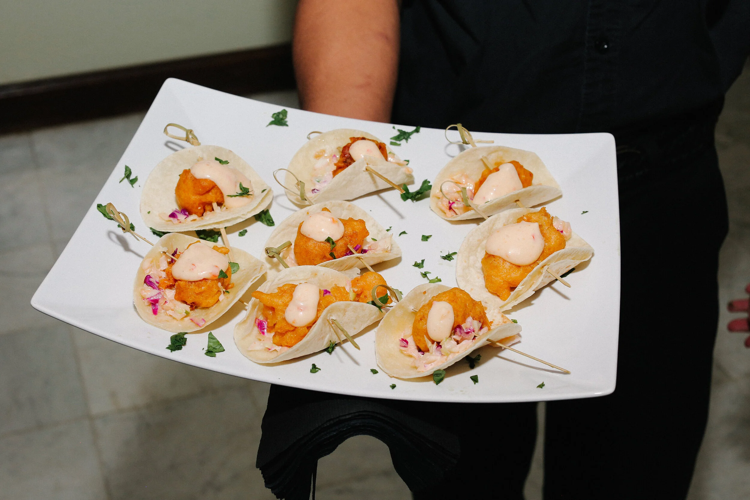 Passed hors d'oeuvres by luxury in-house catering at JPS Events at Regions Tower: a plate of mini tacos with fried fish, cabbage, onions, and sauce—imaginative takes on classic wedding food in Downtown Indianapolis.