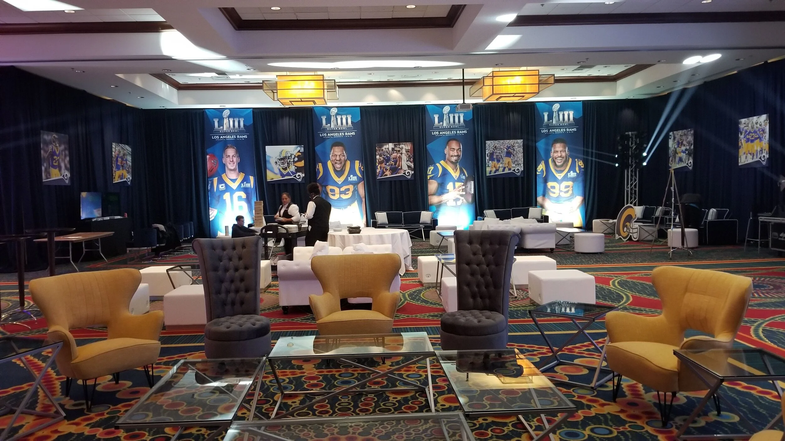 Interior of a room decorated for an LA Rams Super Bowl event produced by JPS Events, featuring large banners with player images and team logos, with seating and full venue event setup in place in a luxury setting.  