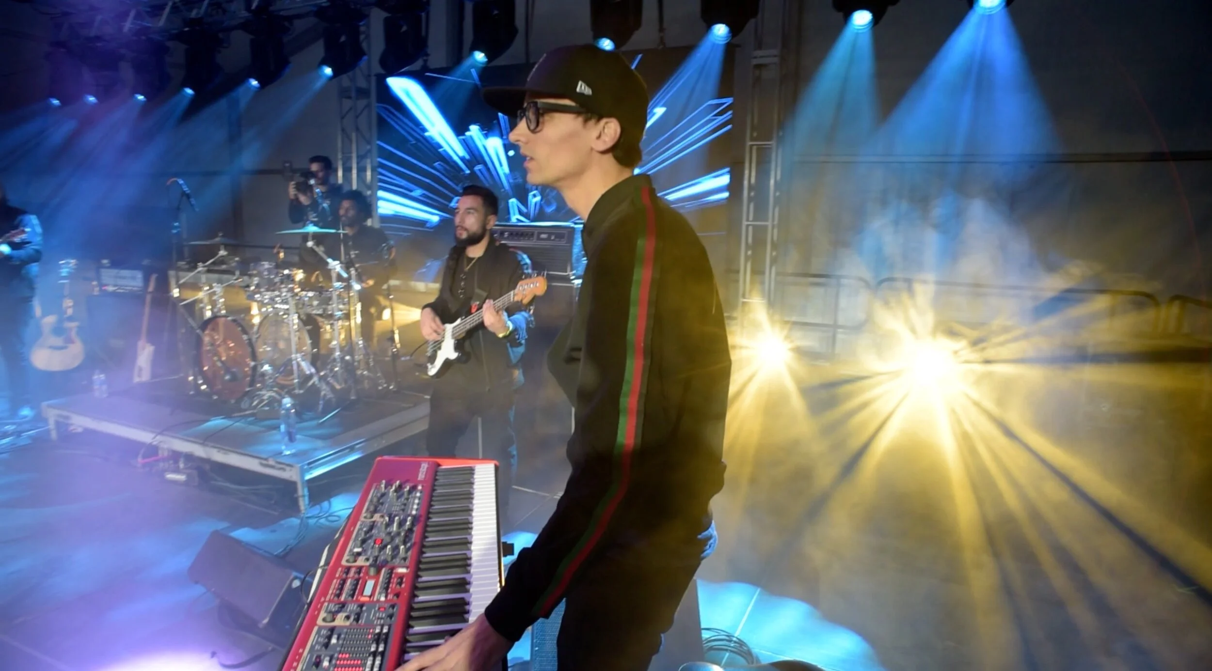 A musician playing keyboard on stage at HOT NYE (formerly CÎROC the New Year) at JPS Events at Regions Tower in Downtown Indianapolis, performing with band members under colorful lights at the Midwest's top NYE venue.  