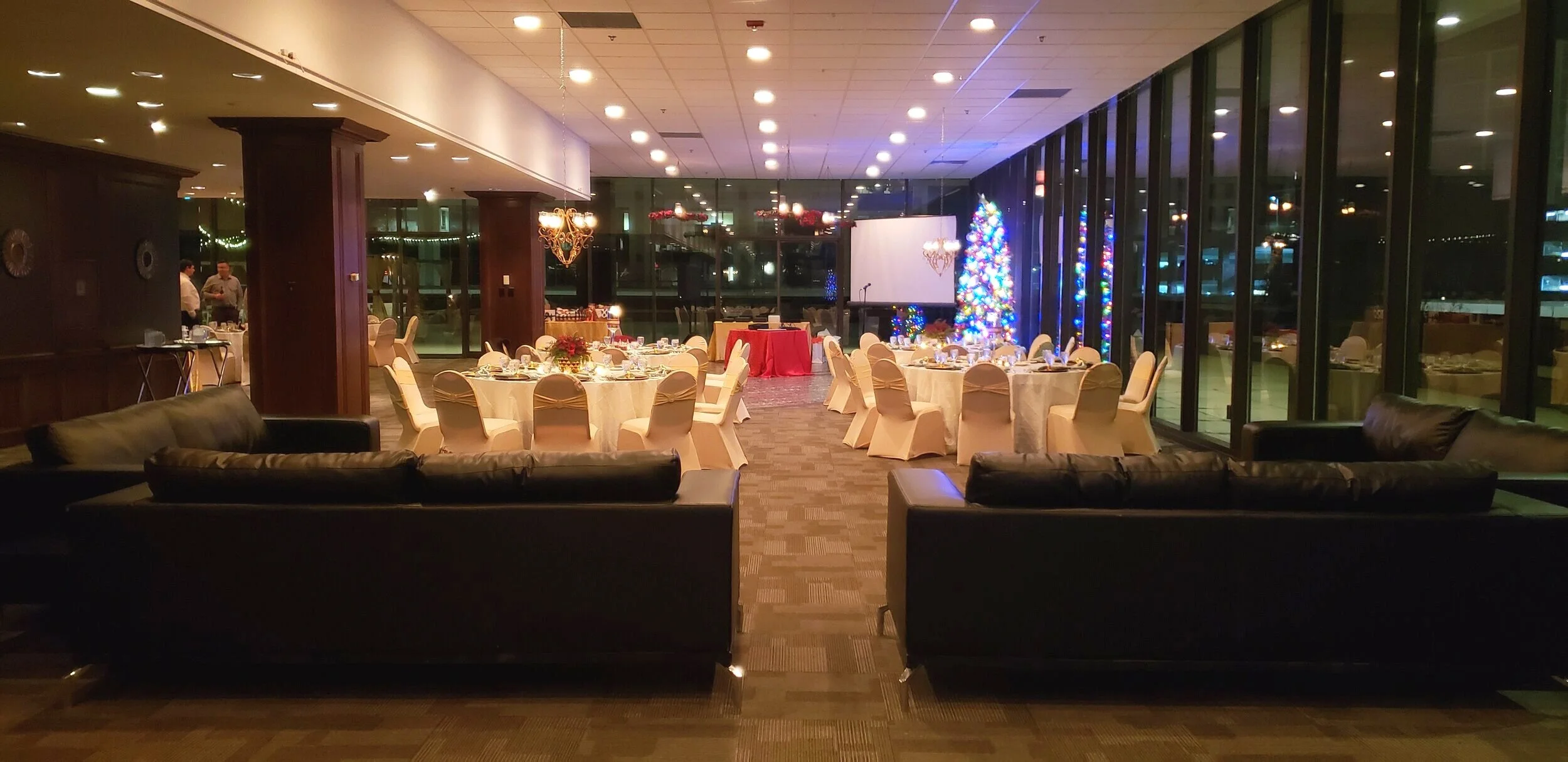 Winter corporate holiday gala in the climate-controlled indoor ballroom at JPS Events at Regions Tower, featuring festive custom lighting, in-house seasonal decor, and panoramic nighttime skyline views.