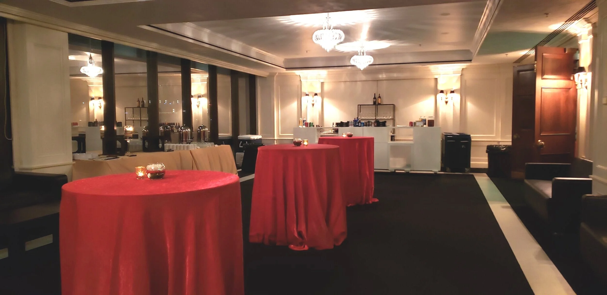 Evening corporate dining setup at JPS Events at Regions Tower, showcasing rich dark wood paneling, warm architectural lighting, and integrated in-house catering and bar programs.