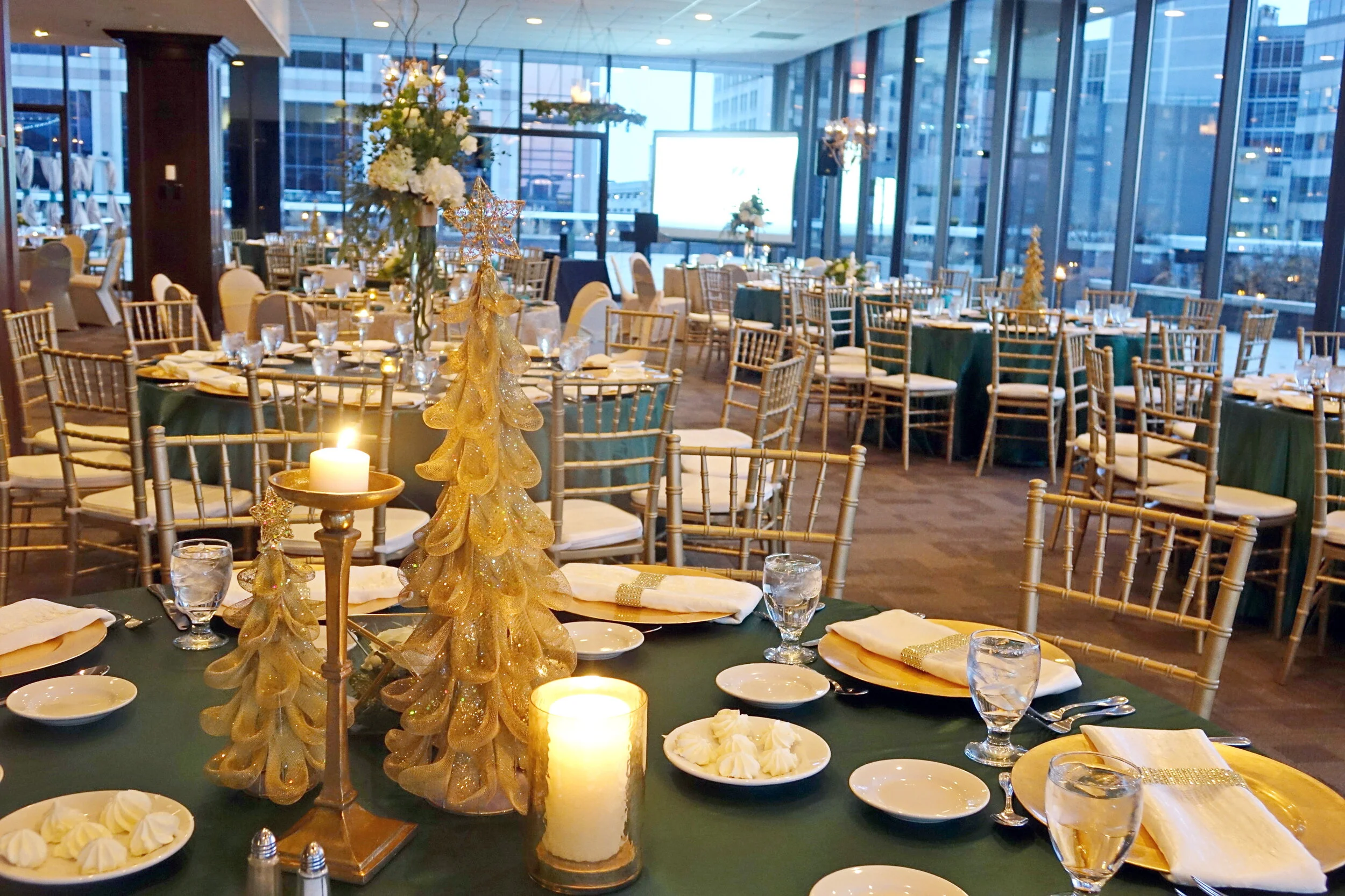 Winter corporate holiday gala in the climate-controlled indoor ballroom at JPS Events at Regions Tower, featuring festive custom lighting, in-house seasonal decor, and panoramic nighttime skyline views.