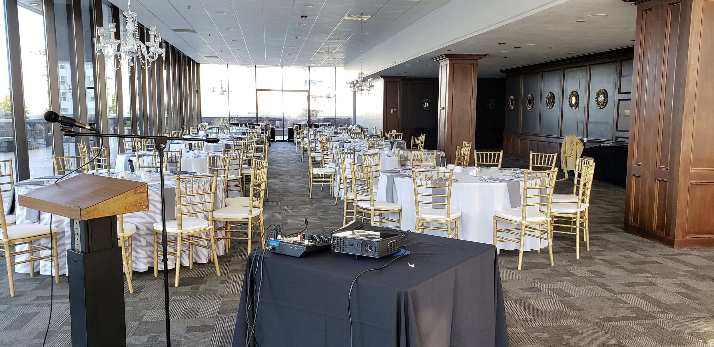 Corporate banquet and presentation setup in the indoor ballroom at JPS Events at Regions Tower, highlighting integrated sound and podium equipment, flexible seating arrangements, and full-service event coordination.