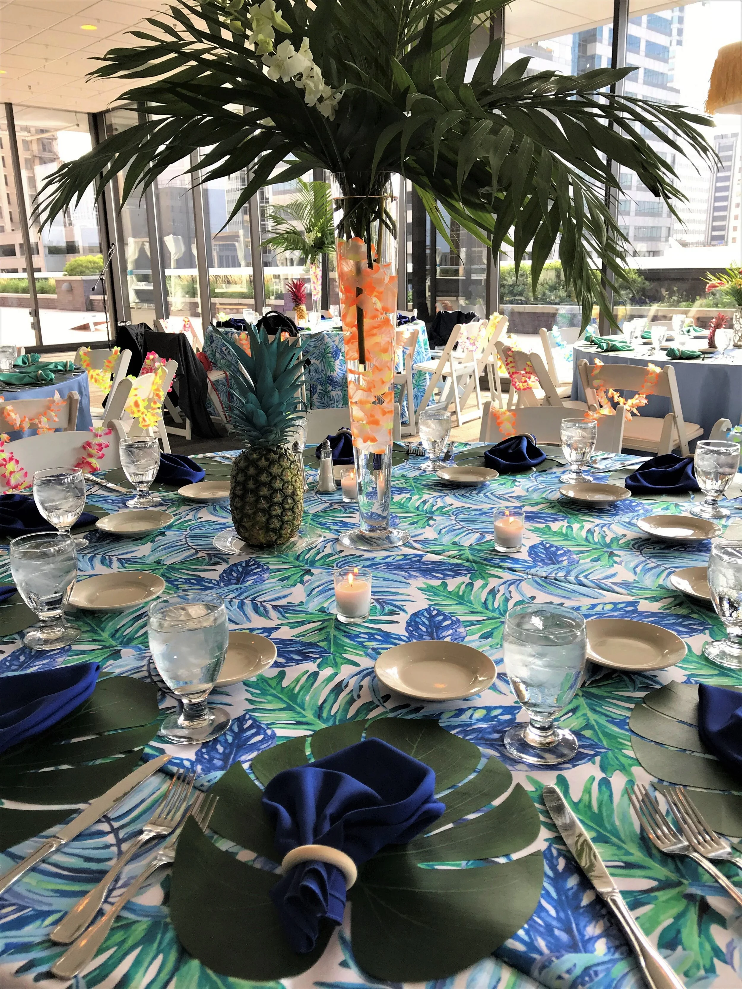 Tropical-themed luxury wedding tablescape designed by the in-house floral and decor team at JPS Events at Regions Tower, showcasing all-inclusive design customization inside the climate-controlled indoor ballroom.