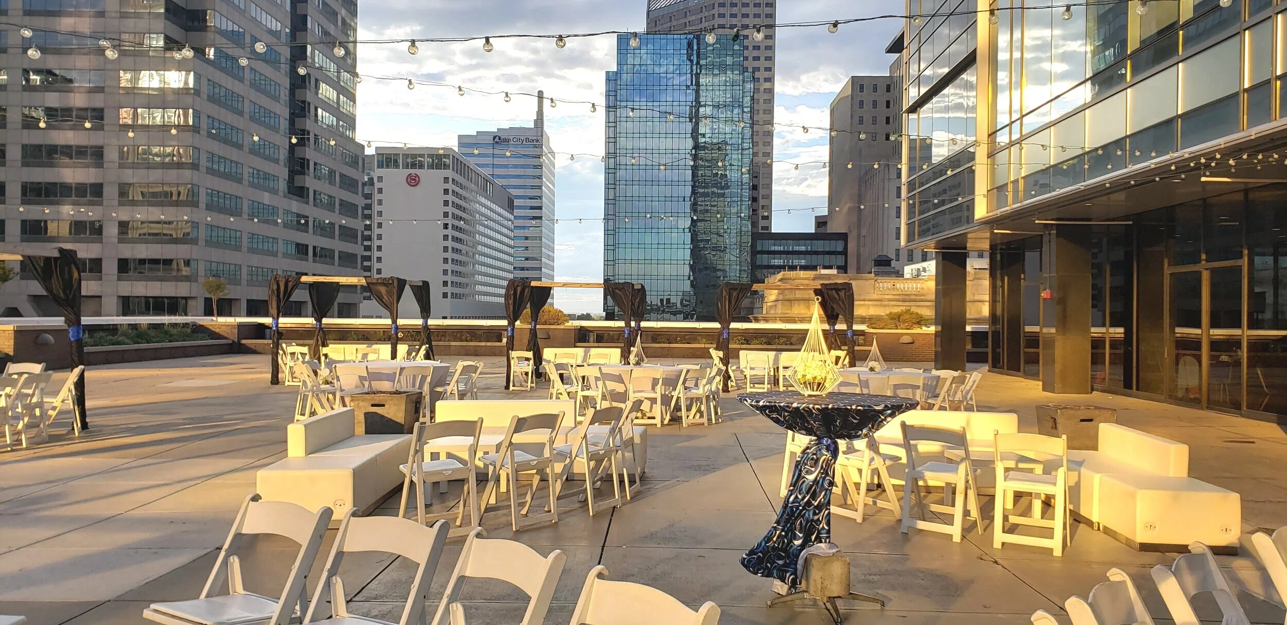 Outdoor rooftop wedding setup on the 11,000 sq. ft. 5th-floor terrace at JPS Events at Regions Tower, featuring golden hour 360-degree downtown Indianapolis skyline views and seamless indoor-outdoor flow.