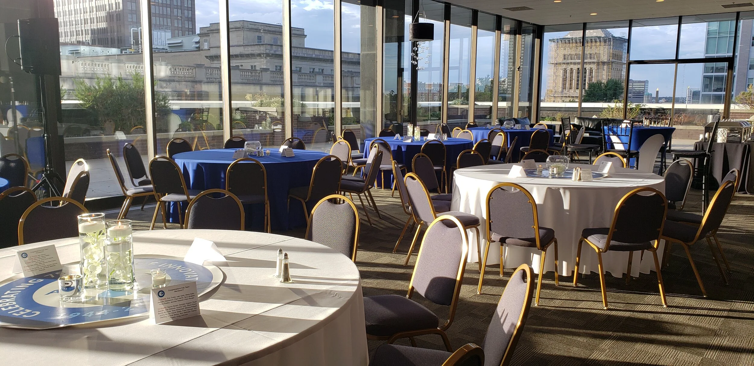 Corporate banquet hall layout inside the modern indoor ballroom at JPS Events at Regions Tower, featuring floor-to-ceiling glass windows, flexible table configurations, and all-inclusive event management.