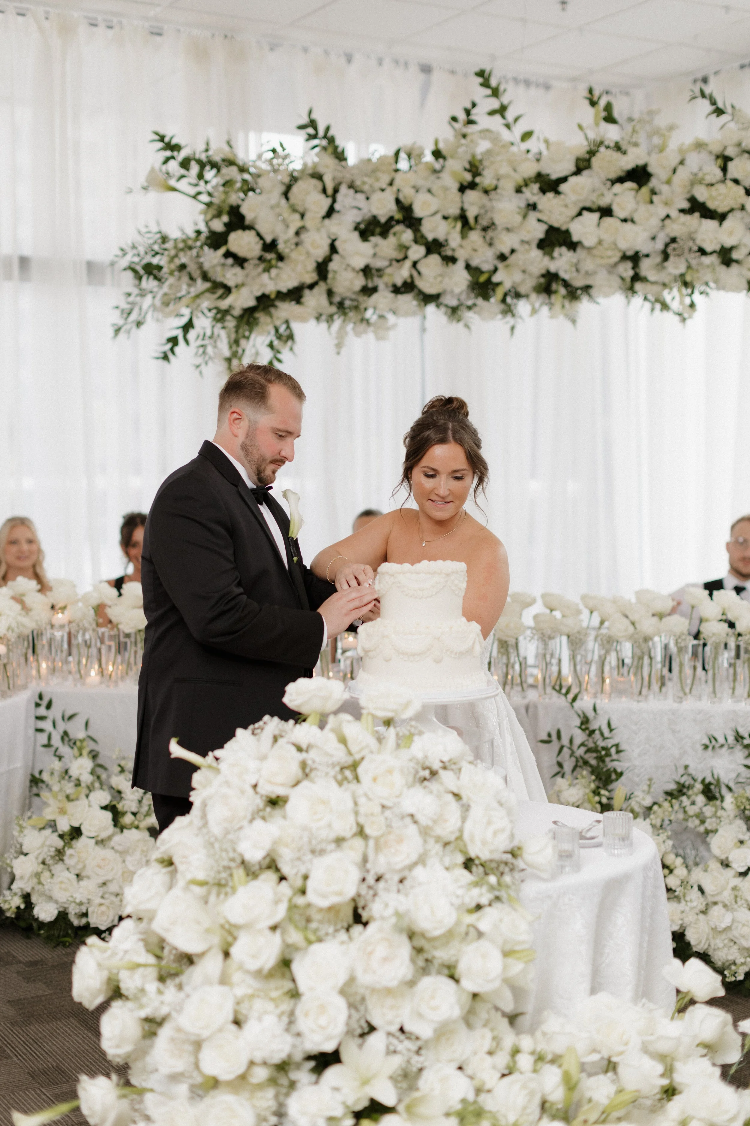 Cake cutting reception at JPS Events at Regions Tower, featuring in-house luxury floral styling, chef-driven catering, polished white marble floors, and built-in day-of wedding coordination in downtown Indy.