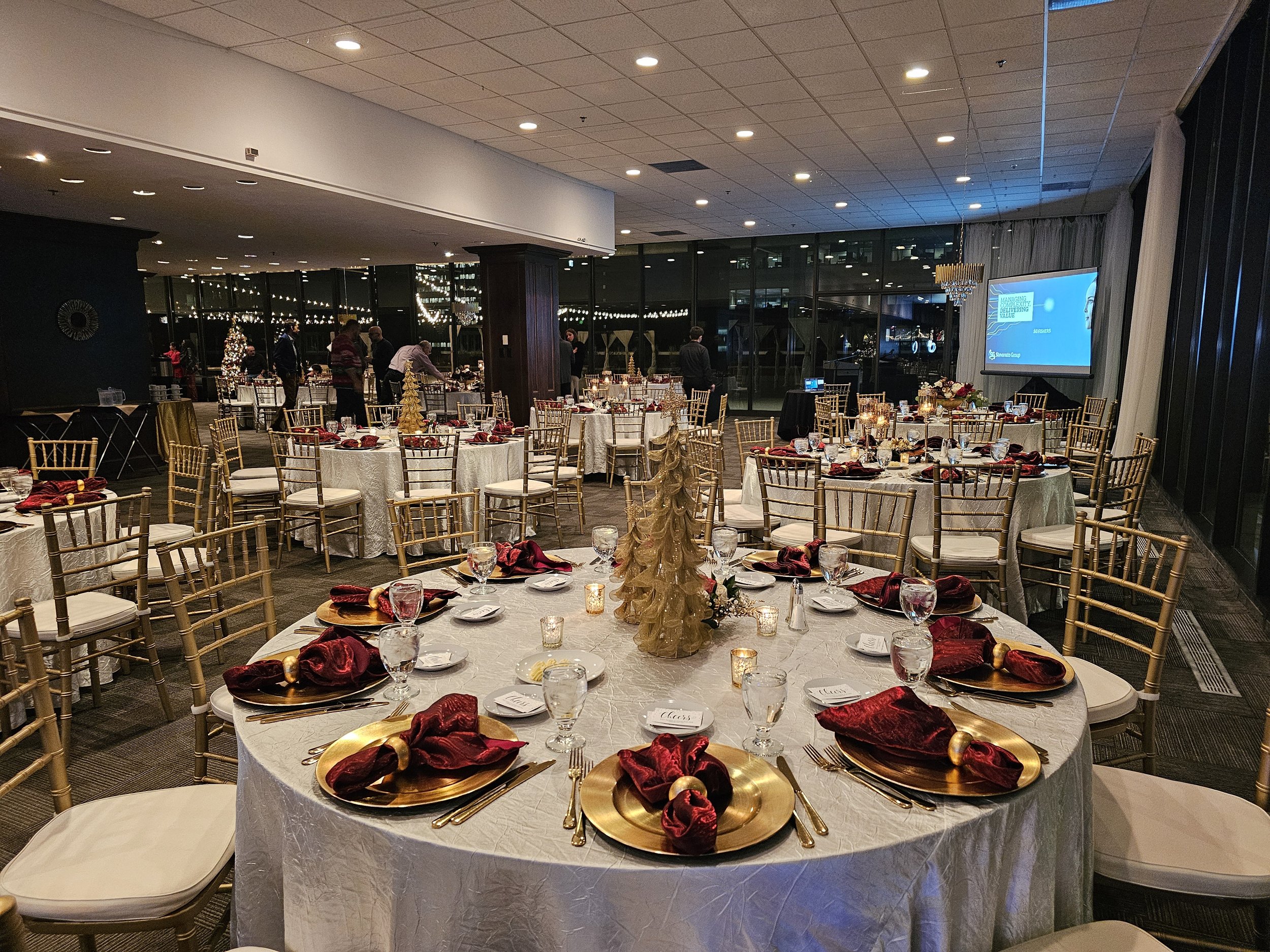 Luxury corporate holiday gala at JPS Events at Regions Tower, showcasing gold dinnerware, in-house floral design, floor-to-ceiling windows, and zero late-out fees in downtown Indianapolis.