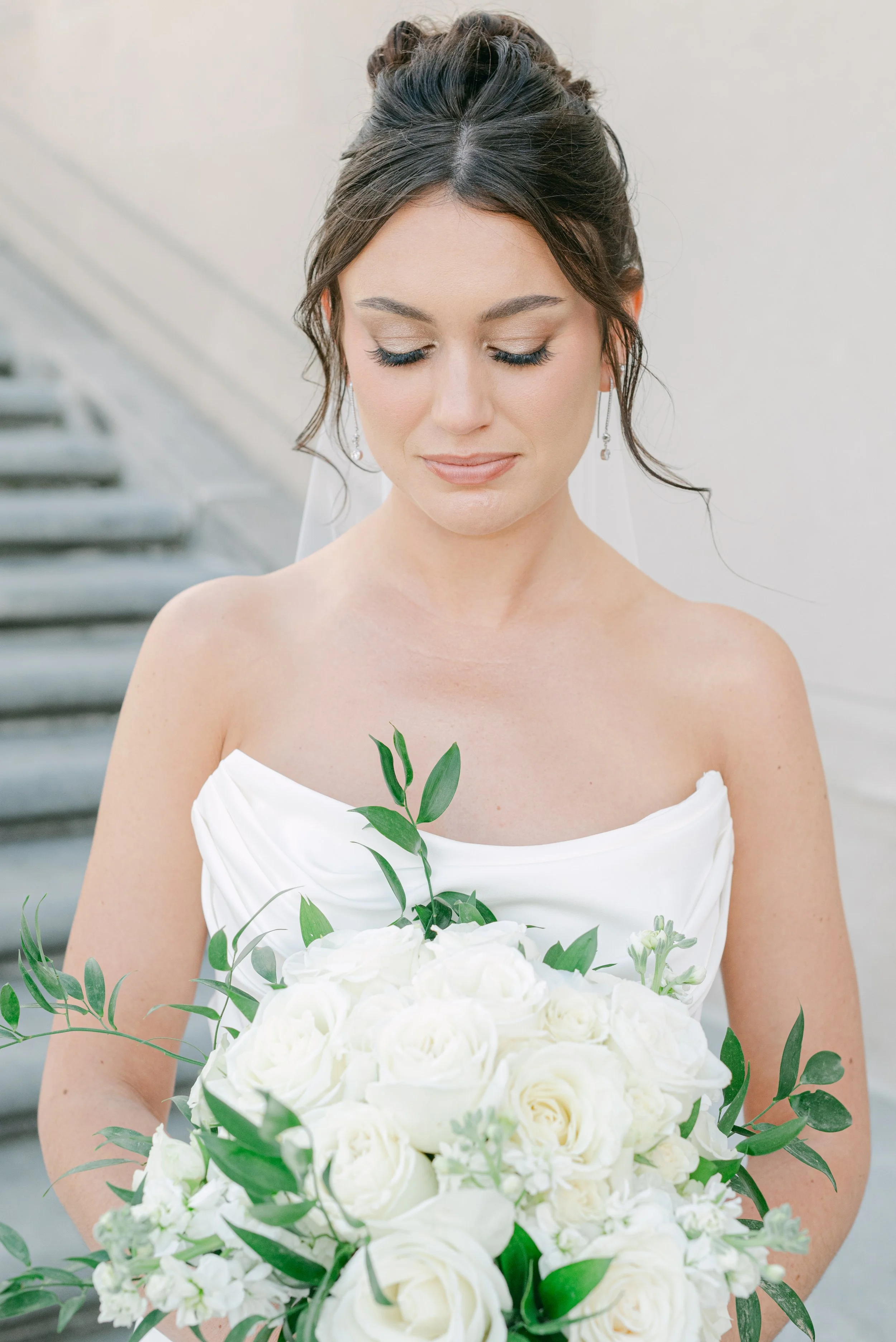 Bride with a custom white rose bouquet designed by the in-house floral team at JPS Events at Regions Tower. Offers over-the-top bridal florals at wholesale pricing & private executive suites in downtown Indy.