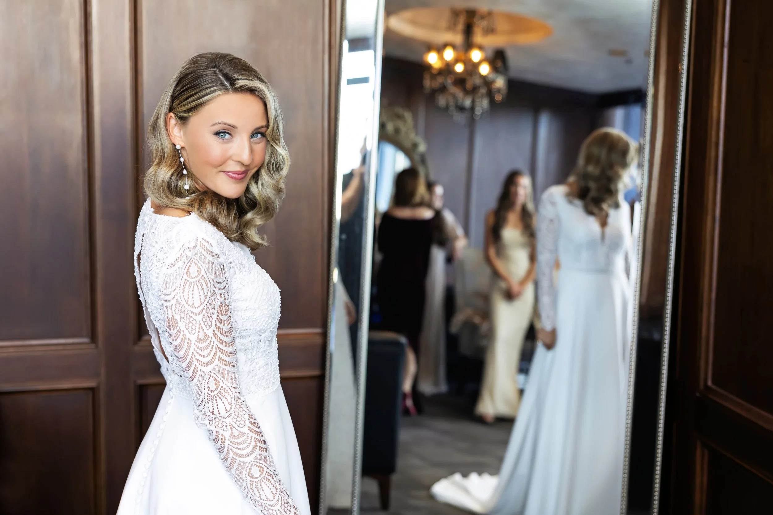 Bride enjoying stress-free morning-of prep in the private executive suite at JPS Events at Regions Tower in downtown Indy. Features luxury dark wood paneling, crystal chandeliers, & hands-on family coordination.