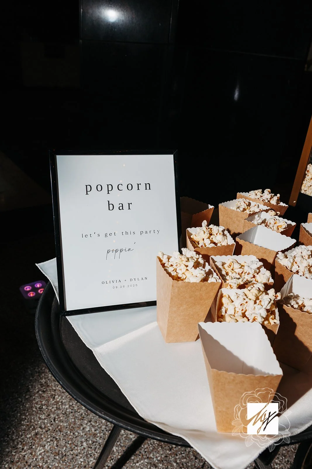 Imaginative takes on classic late night snacks by luxury in-house catering at JPS Events at Regions Tower in Downtown Indy: a popcorn bar tray in paper containers with a sign for Olivia and Dylan's 09.26.2025 reception.  