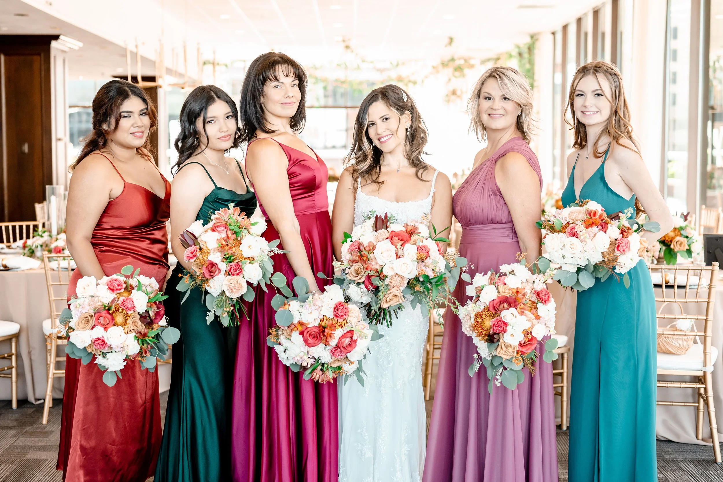 Bridesmaids holding bespoke jewel-tone bouquets designed by the in-house floral team at JPS Events at Regions Tower. Showcases fully custom wedding floral palettes at wholesale pricing with all-inclusive planning in downtown Indy.