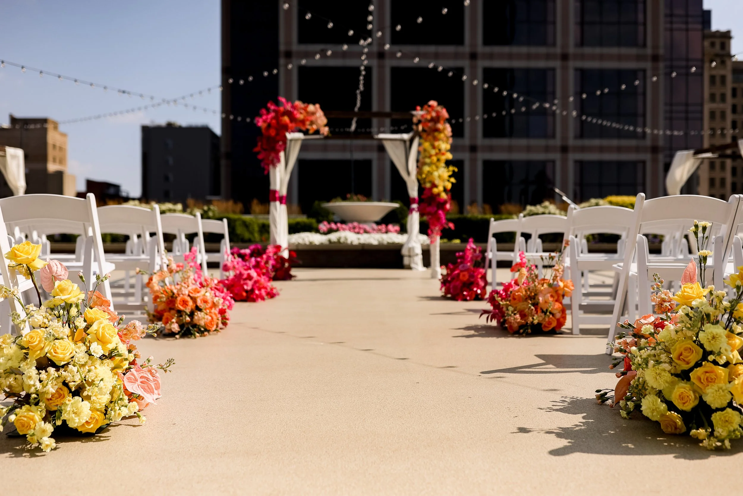 Outdoor ceremony setup on the 11,000 sq ft terrace at JPS Events at Regions Tower, featuring custom aisle florals by our in-house team at wholesale pricing. Full setup and teardown included with zero late-out fees in Indy.