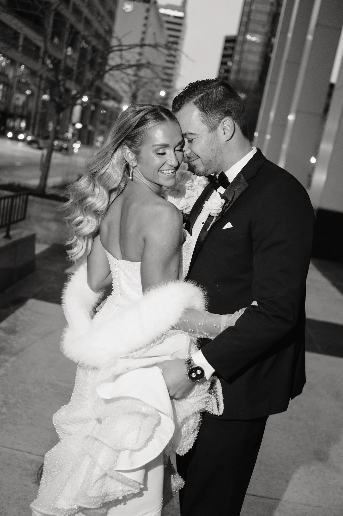 Black-and-white photo of a bride and groom touching foreheads during an outdoor night reception on the 5th-floor rooftop terrace at JPS Events at Regions Tower, Downtown Indianapolis's premier all-inclusive luxury skyline venue.