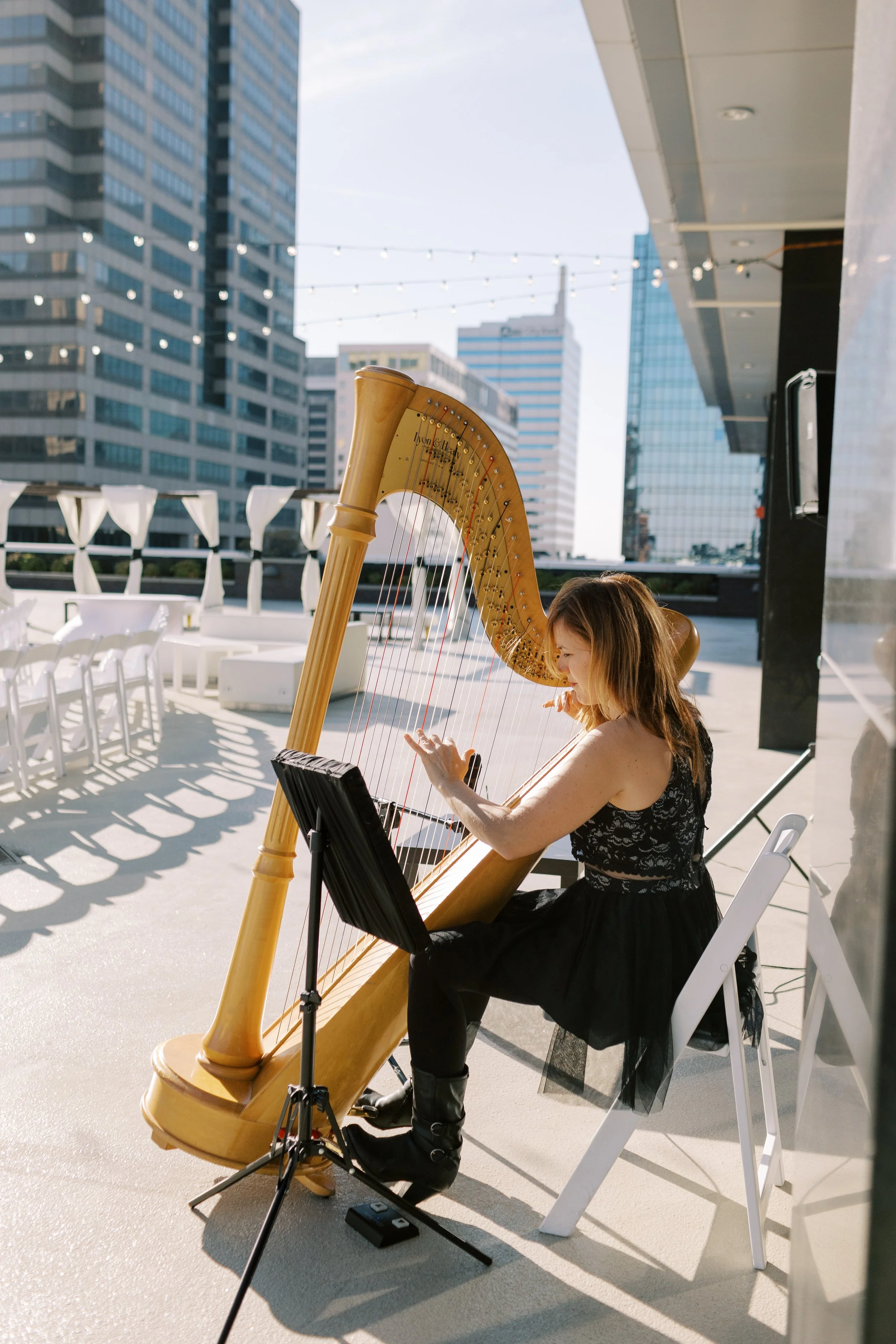Live harpist performing on the open-air rooftop terrace at JPS Events at Regions Tower in downtown Indy. Highlights custom ceremony acoustics, integrated AV power support, 360 skyline backdrops, & full-service planning.