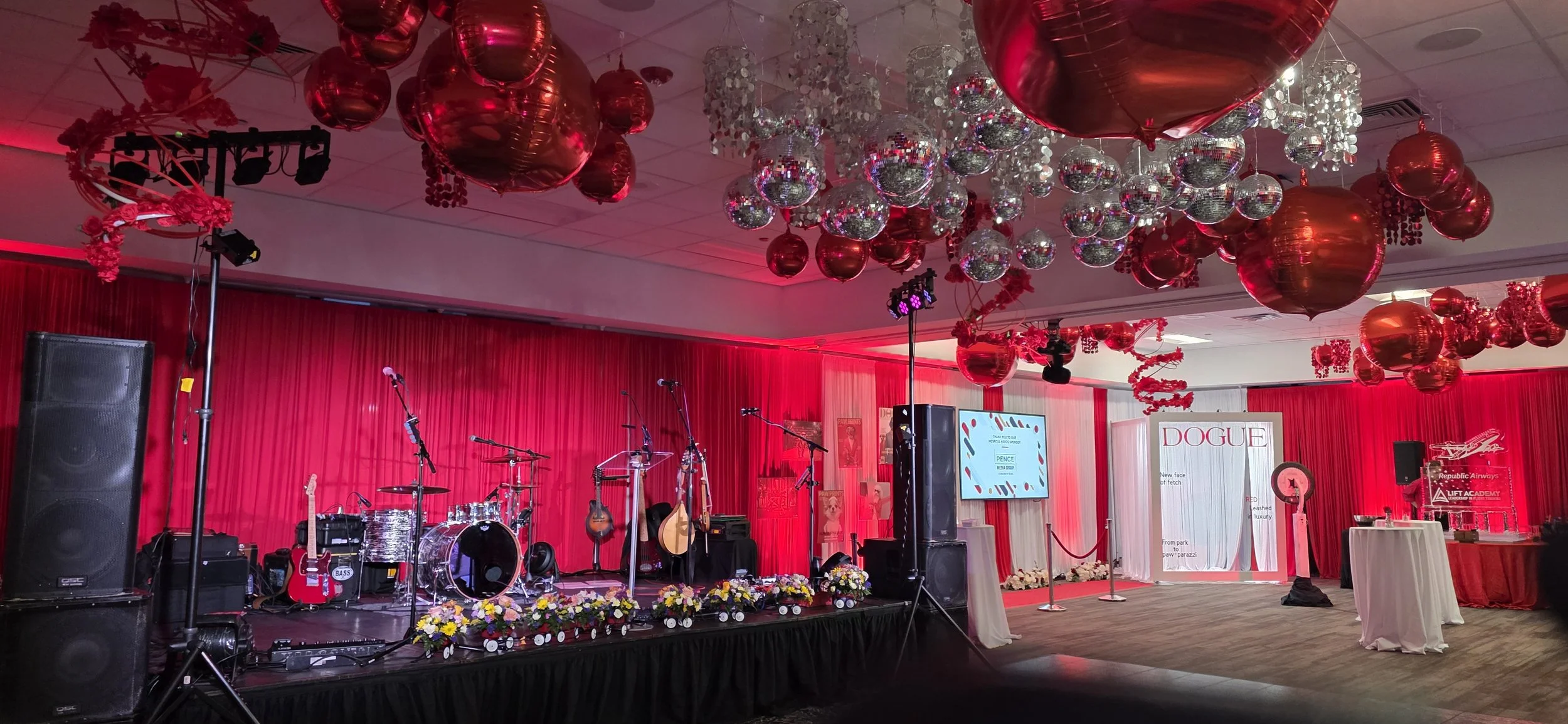 Stage setup for the Riley RED Gala at JPS Events at Regions Tower, showcasing custom stage production, in-house floral arrangements, red balloon arches, and integrated AV capabilities in downtown Indianapolis.