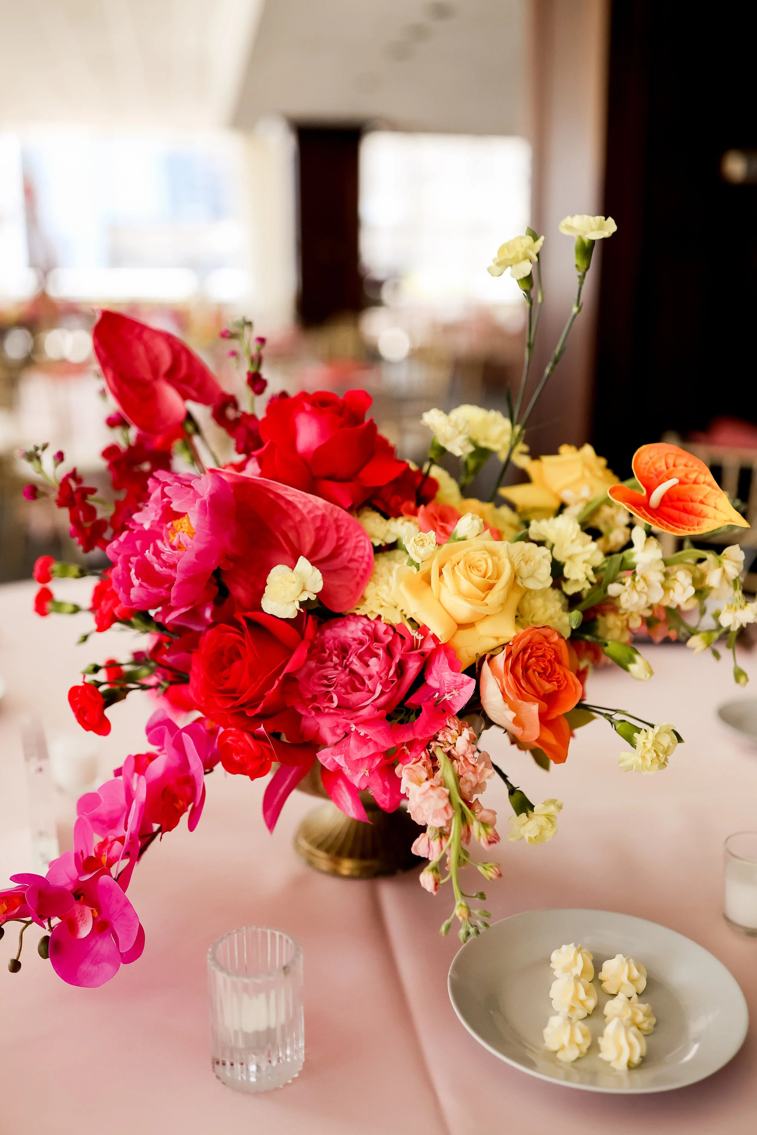 Bright floral centerpiece paired with gourmet plated desserts at JPS Events at Regions Tower. Demonstrates the seamless synergy between our chef-driven in-house catering and custom wholesale floral design in downtown Indianapolis.