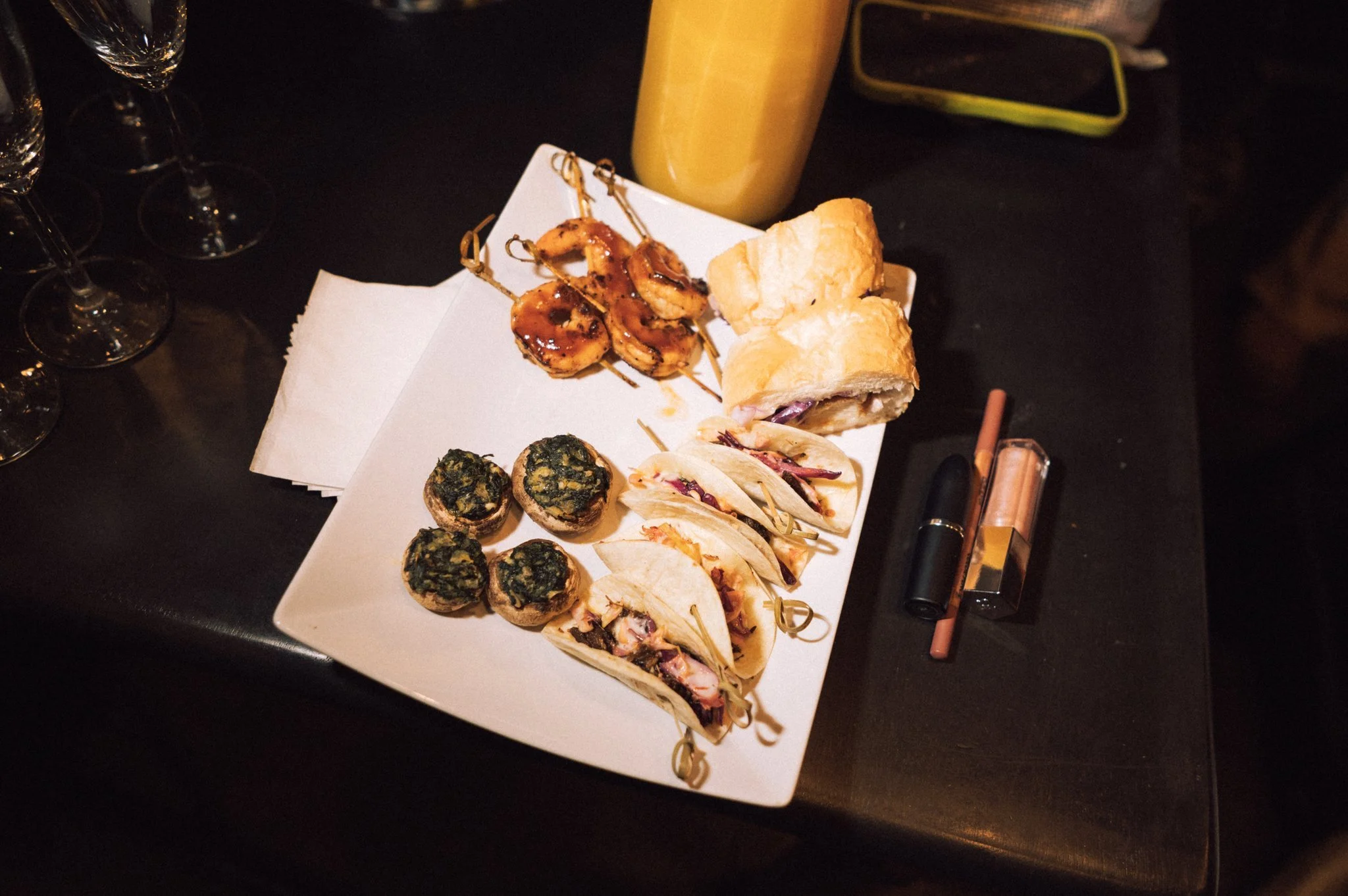 Passed hors d'oeuvres and custom menus from luxury in-house catering at JPS Events at Regions Tower in Downtown Indy: a white rectangular platter with assorted appetizers, grilled shrimp skewers, stuffed mushrooms, and tacos.